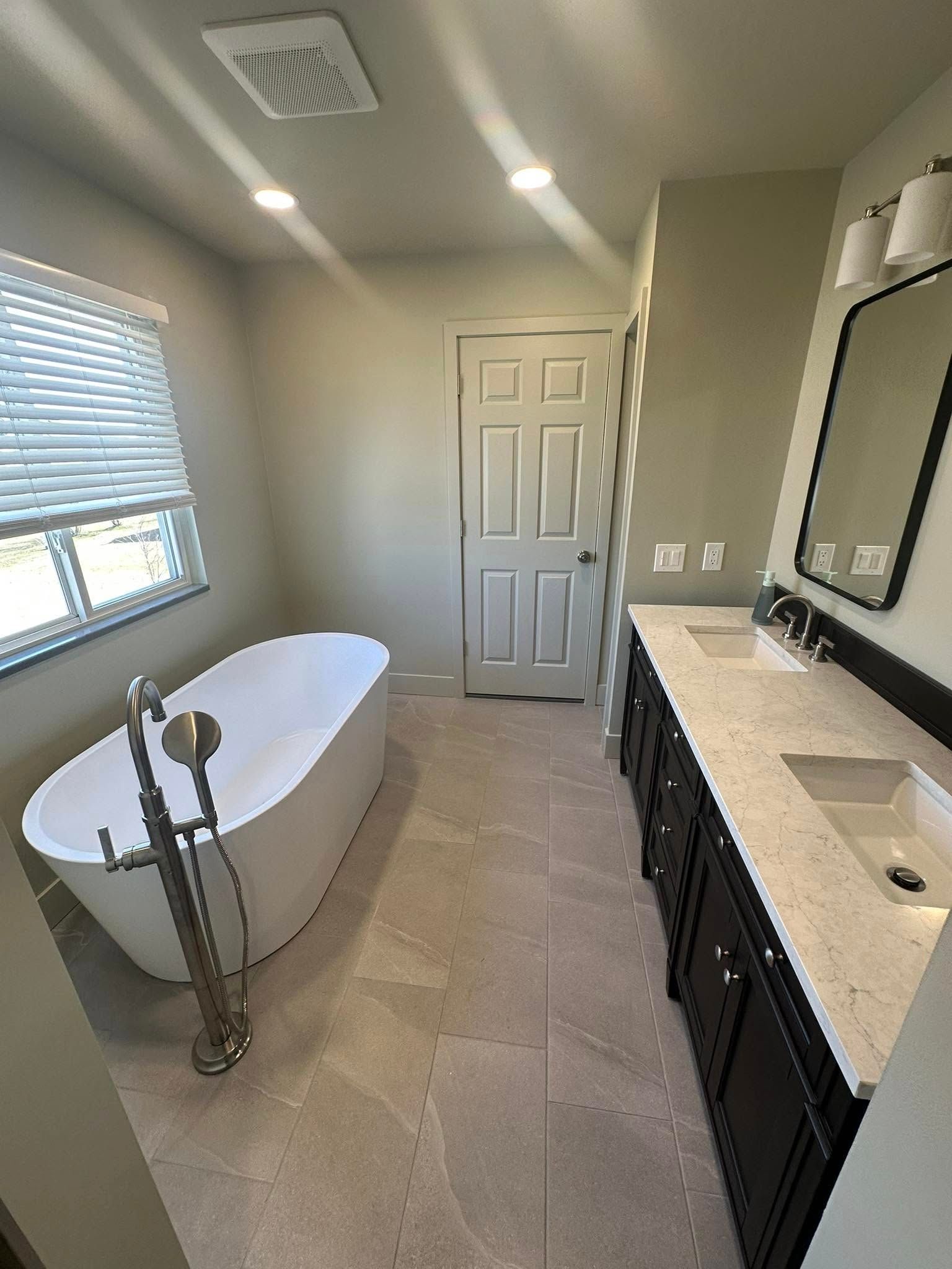 A bathroom with a bathtub and two sinks.