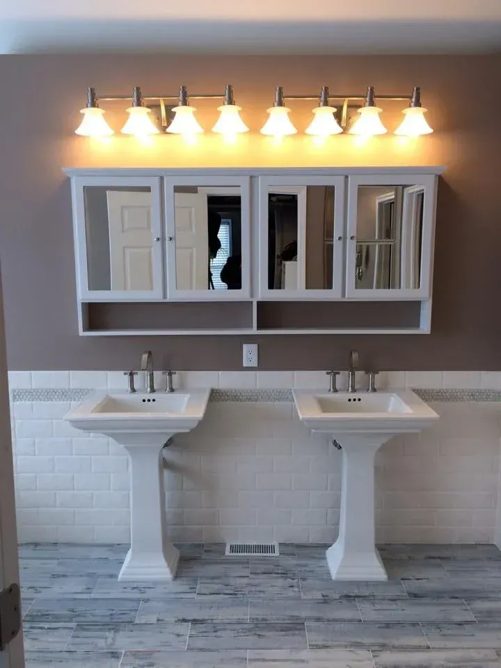 A bathroom with two sinks and a mirror above them