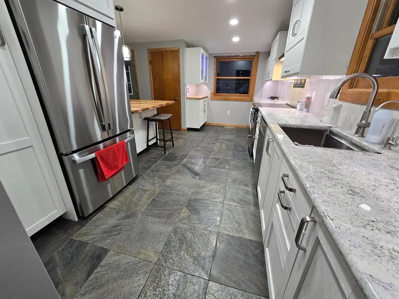 A kitchen with stainless steel appliances and granite counter tops.
