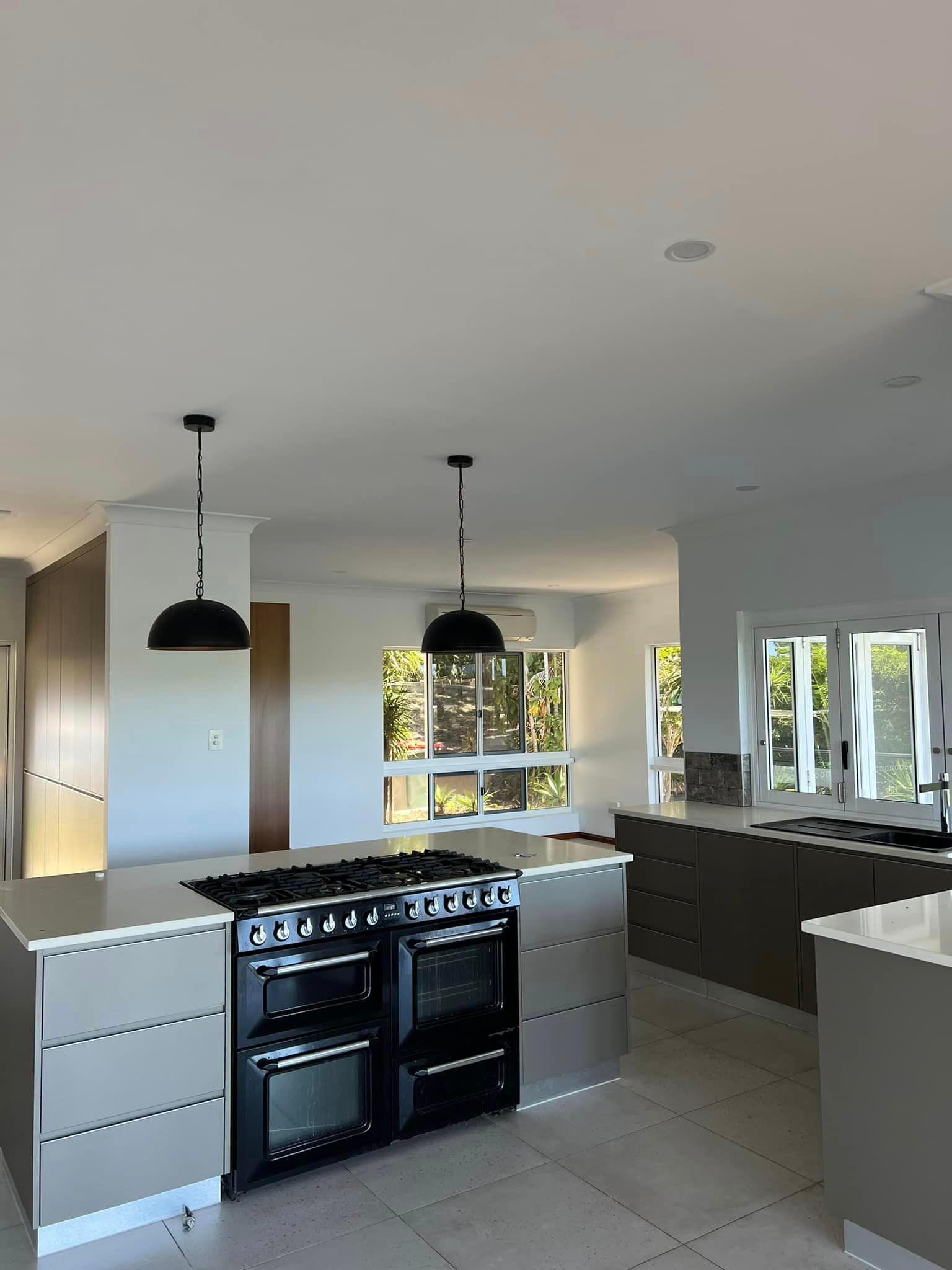 A kitchen with a stove , oven , and sink.