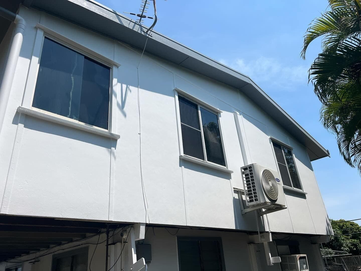 A White Building with A Lot of Windows and Air Conditioners — Darren Smith Painting Pty Ltd in Mackay, QLD