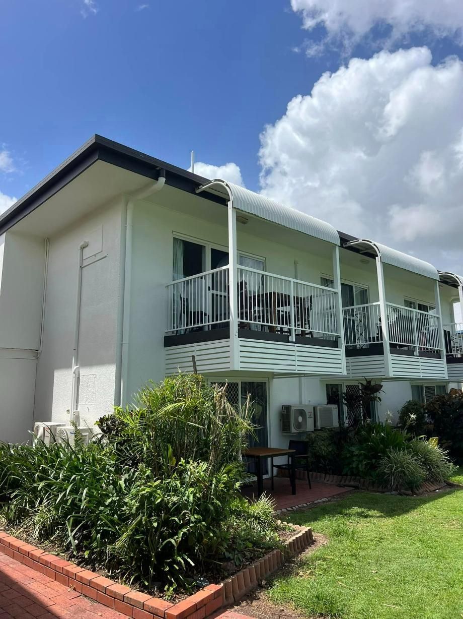 A White Building with A Balcony and A Blue Sky in The Background — Darren Smith Painting Pty Ltd in Mackay, QLD