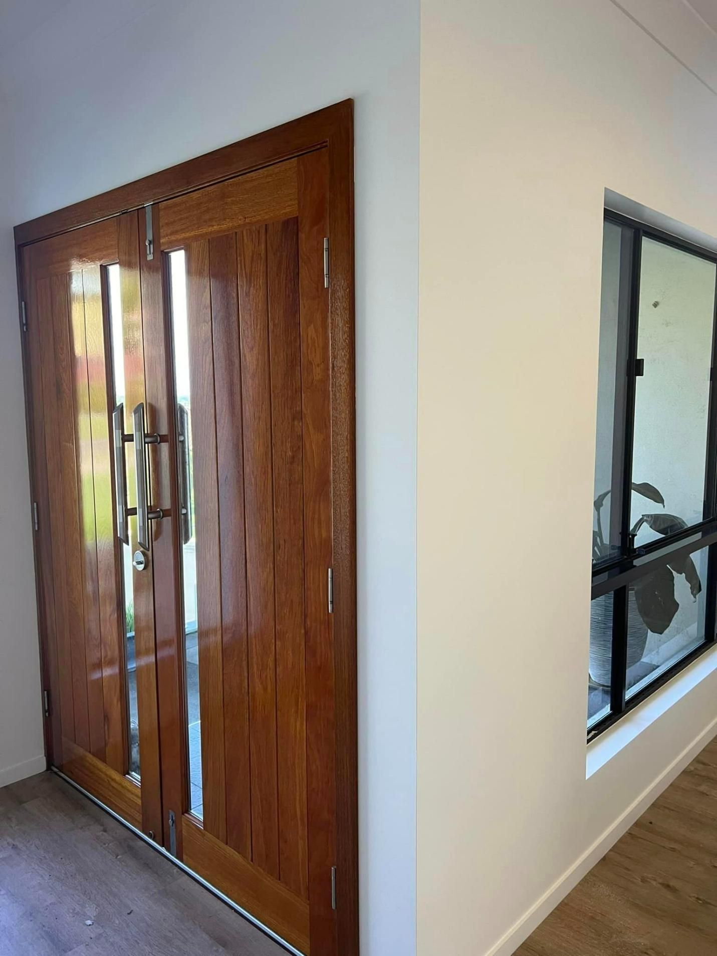 A Hallway with A Wooden Door and A Window — Darren Smith Painting Pty Ltd in Rural View, QLD