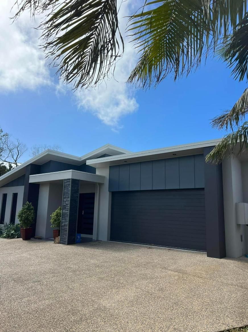A Large House with A Garage and A Palm Tree in Front of It — Darren Smith Painting Pty Ltd in Northern Beaches, NSW