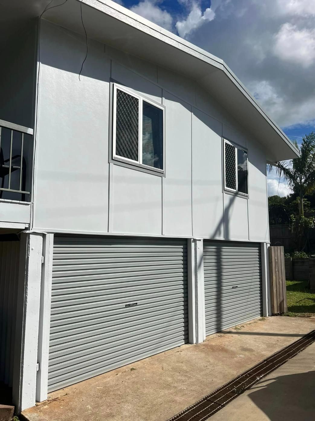 A White House with Gray Garage Doors and A Balcony — Darren Smith Painting Pty Ltd in Mirani, QLD