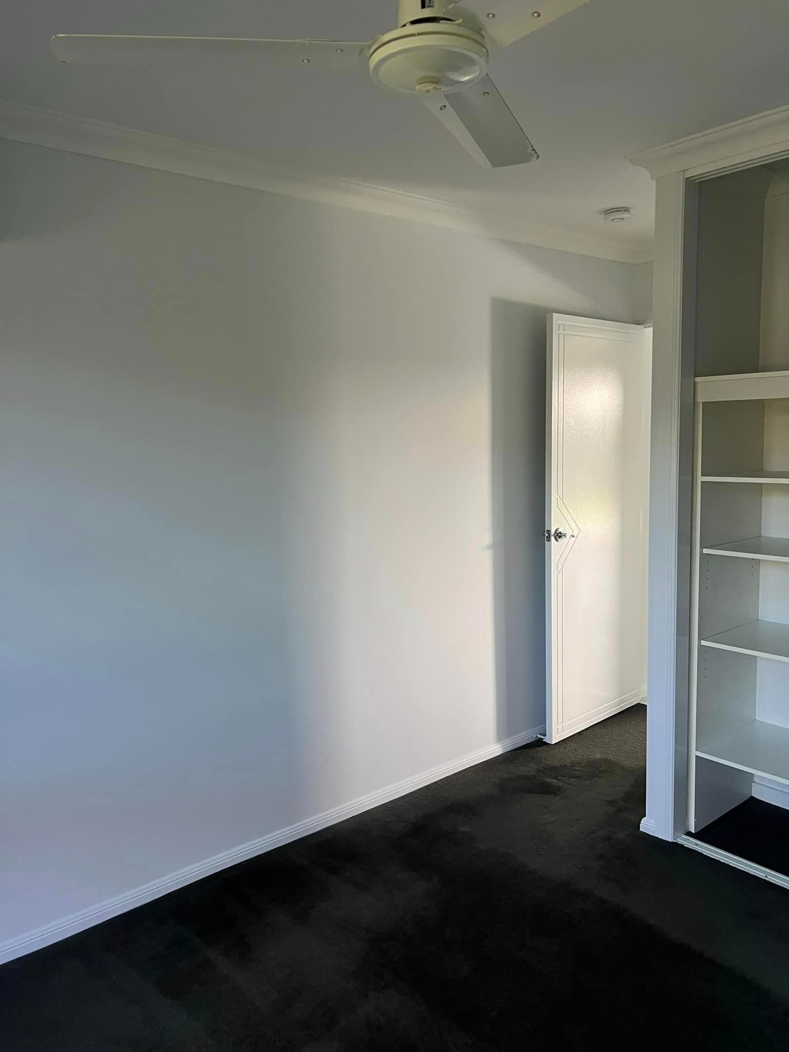 An Empty Room with A Ceiling Fan and A Door — Darren Smith Painting Pty Ltd in Mirani, QLD