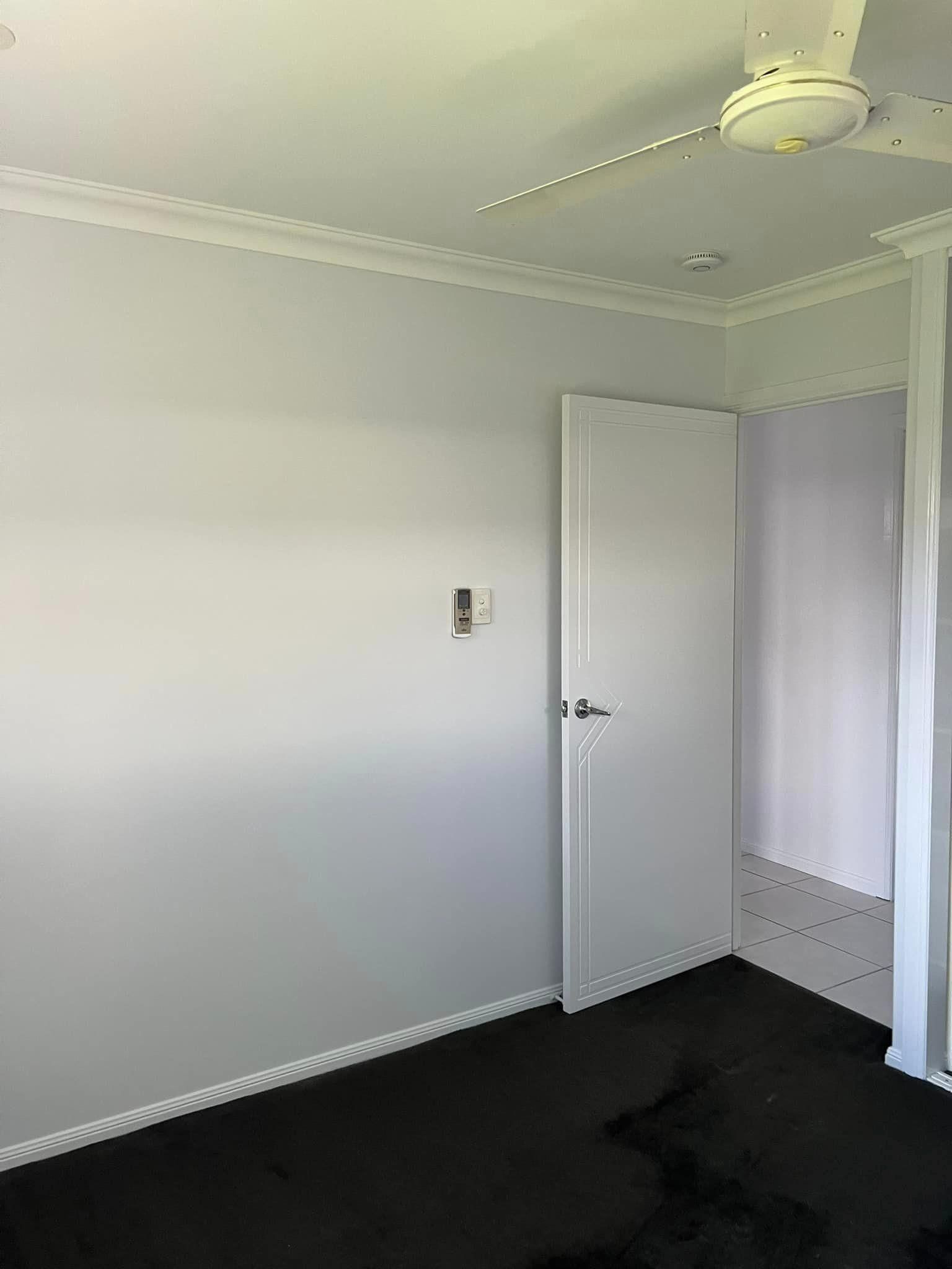 A Bedroom with A Ceiling Fan and A Door — Darren Smith Painting Pty Ltd in Northern Beaches, NSW