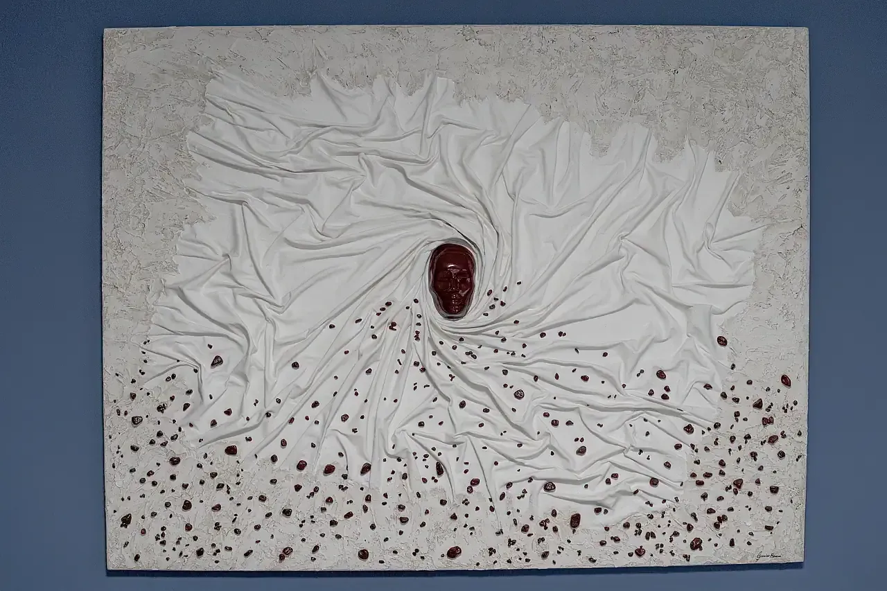 Scultura tridimensionale su tela raffigurante un volto umano in gesso ceramico color bordeaux. L'opera presenta un drappeggio a spirale in telo resinato bianco con inclusioni bordeaux. Opera unica di Guerino Rusconi