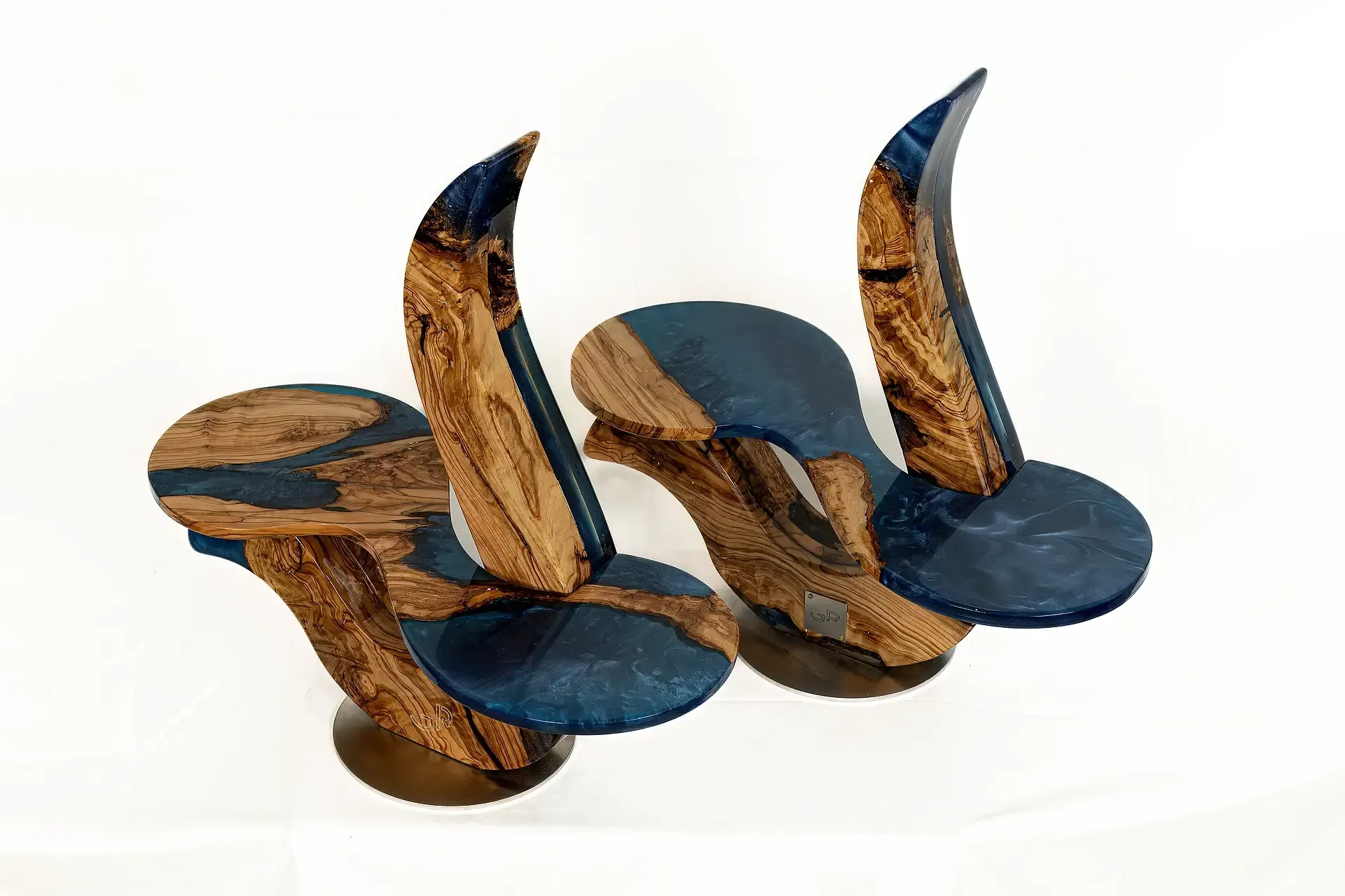 Coppia di porta-piatti in resina epossidica (blu traslucida) e legno di ulivo. Design moderno-contemporaneo. Sculture funzionali di Guerino Rusconi per l'arredamento di interni domestici o per la ristorazione.