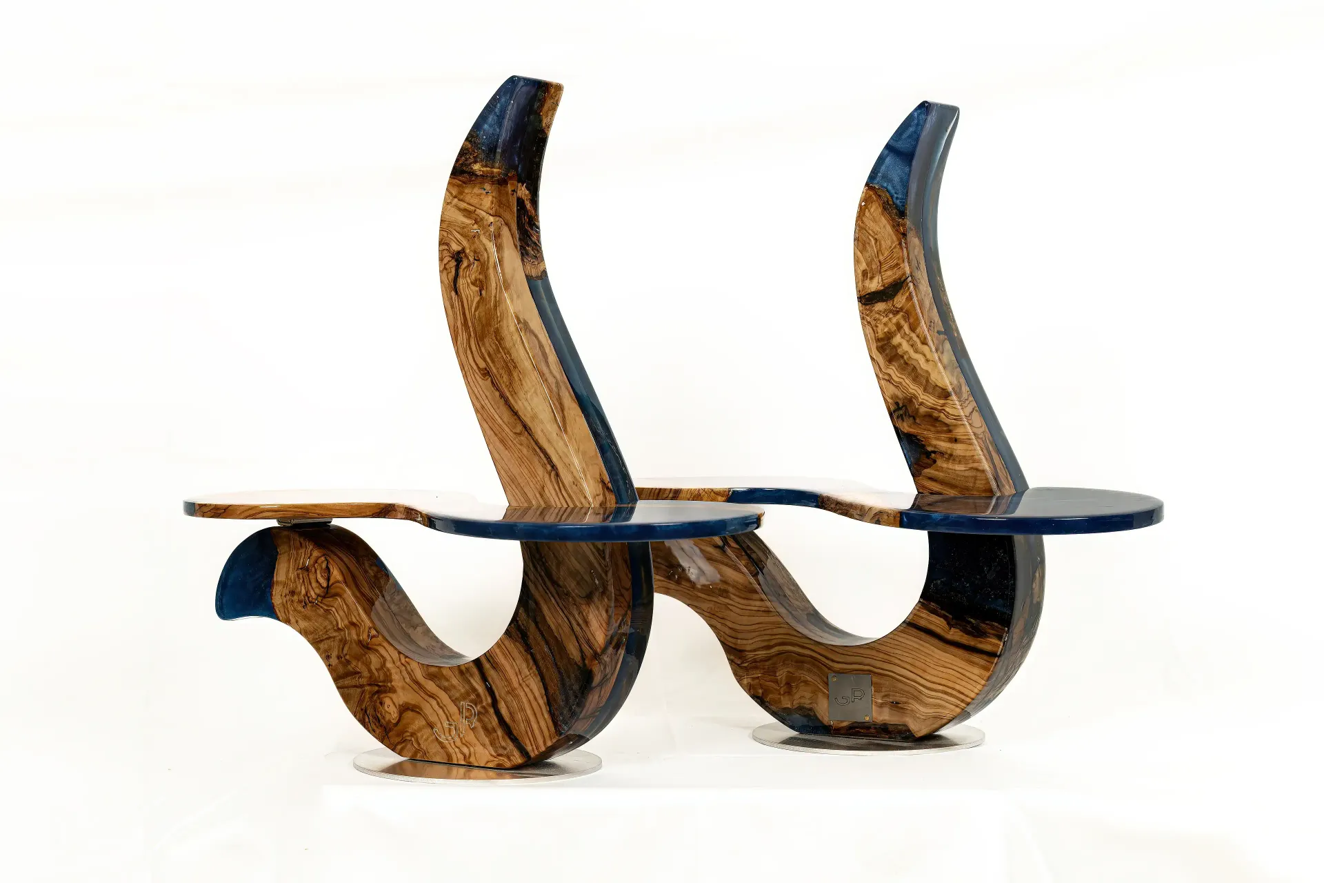 Coppia di sculture funzionali in resina epossidica e legno di ulivo raffiguranti due porta piatti con andamento curvilineo.