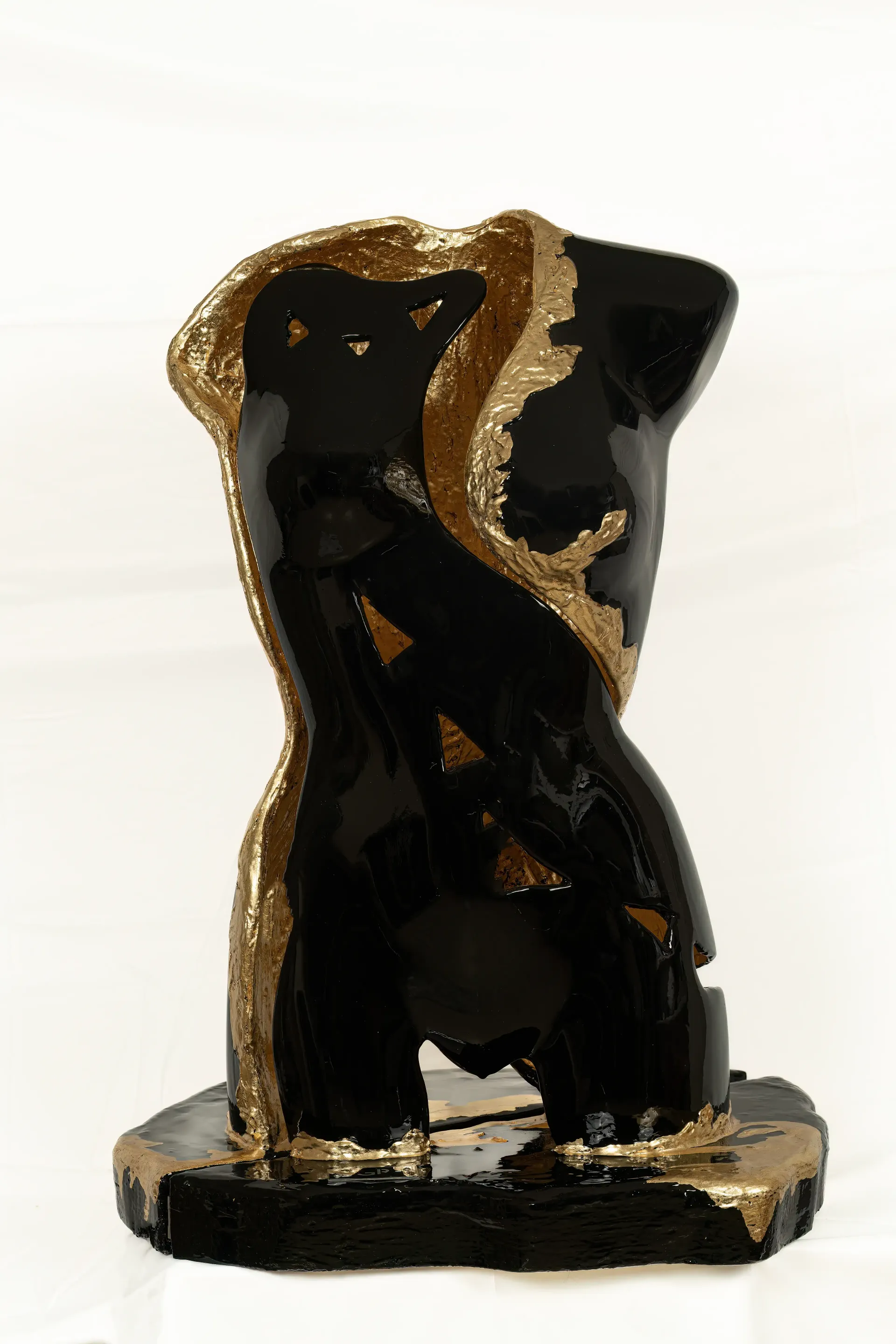 Scultura-Lampada in resina nera e foglia d'oro di torso femminile, corpo cavo con alla base luci led. L'opera in nero lucido e oro ruvido è inquadrata frontalmente, mostrando la divisione netta tra i materiali. Opera unica di Guerino Rusconi.