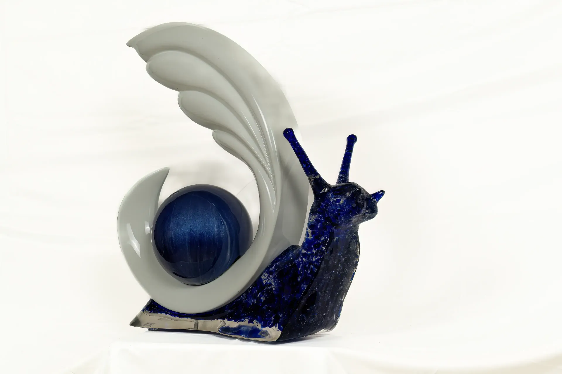 Scultura tridimensionale raffigurante una chiocciola realizzata con corpo in resina blu intenso e legno. Opera dell'artista-artigiano soncinese Guerino Rusconi.