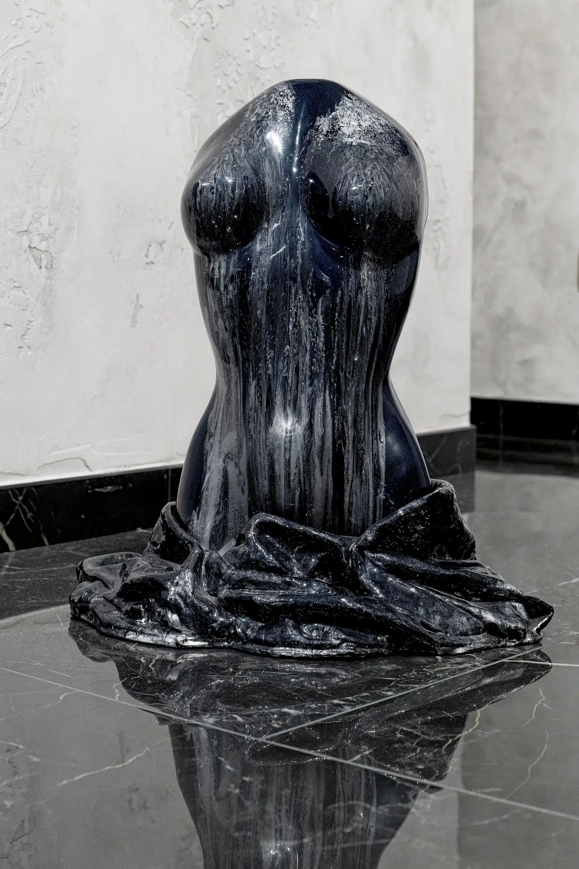 Scultura bifrontale di torso femminile in resina nera e argento vista posteriore. La parte posteriore dell'opera mostra una dominante nera con colature argentate che creano un effetto dinamico sulla superficie. Opera di Guerino Rusconi.