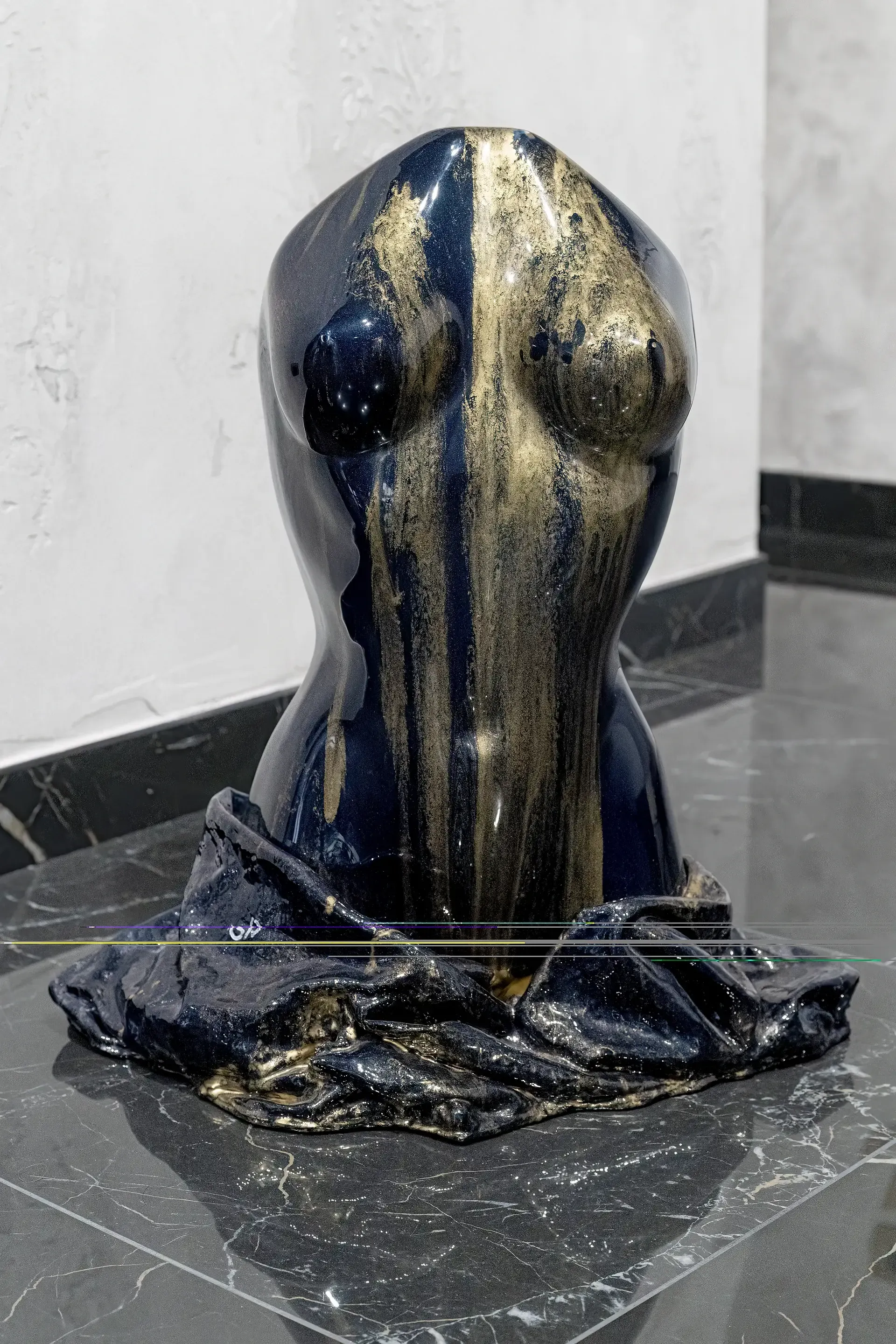 Scultura bicefala di torso femminile in resina nera e oro vista frontale. La parte anteriore dell'opera presenta una dominante blu con accenti dorati che delineano la forma e la superficie. Opera di Guerino Rusconi.
