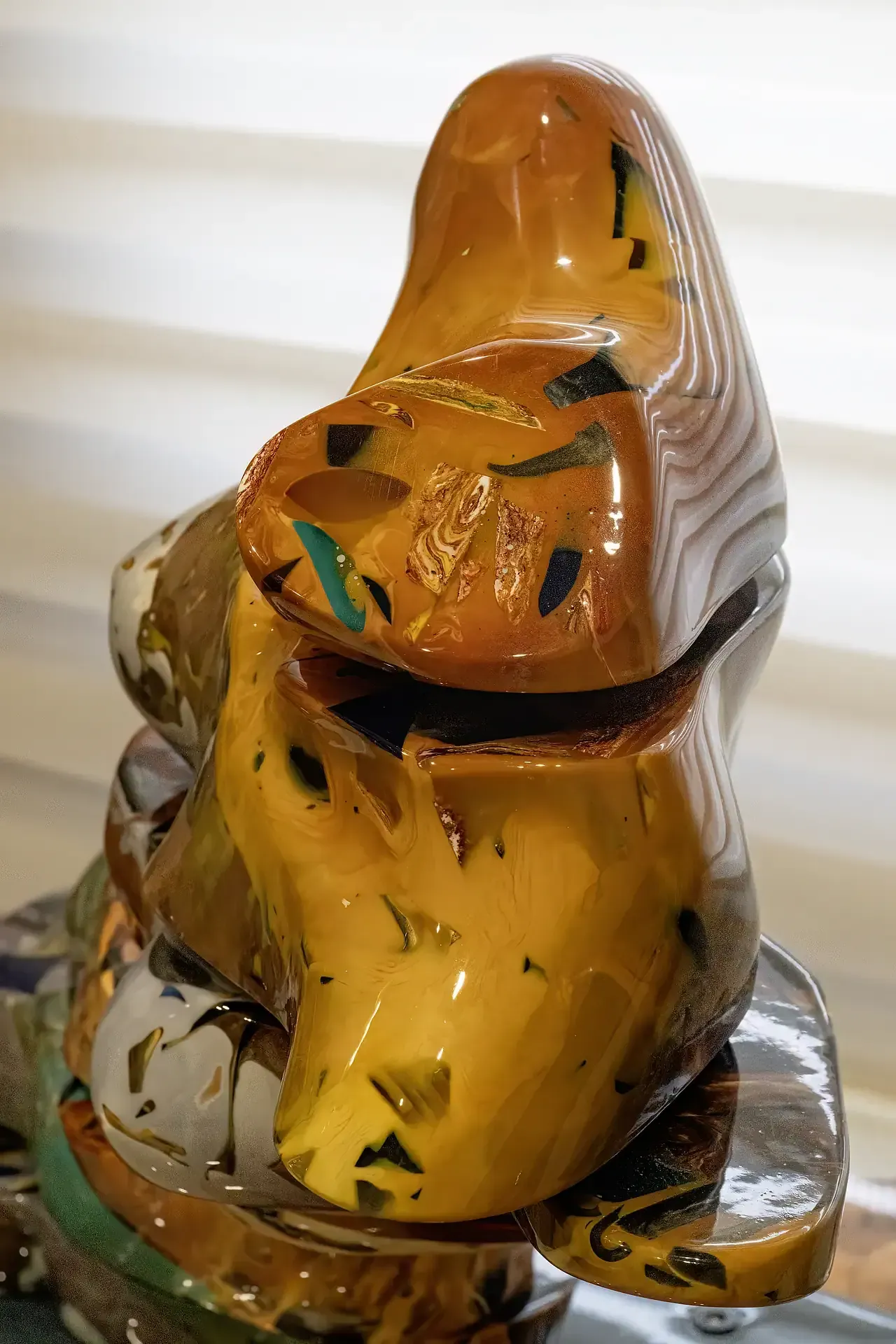 Scultura in resina, astratta, colore giallo-arancio con inclusioni miste, opera in sezioni rotanti.