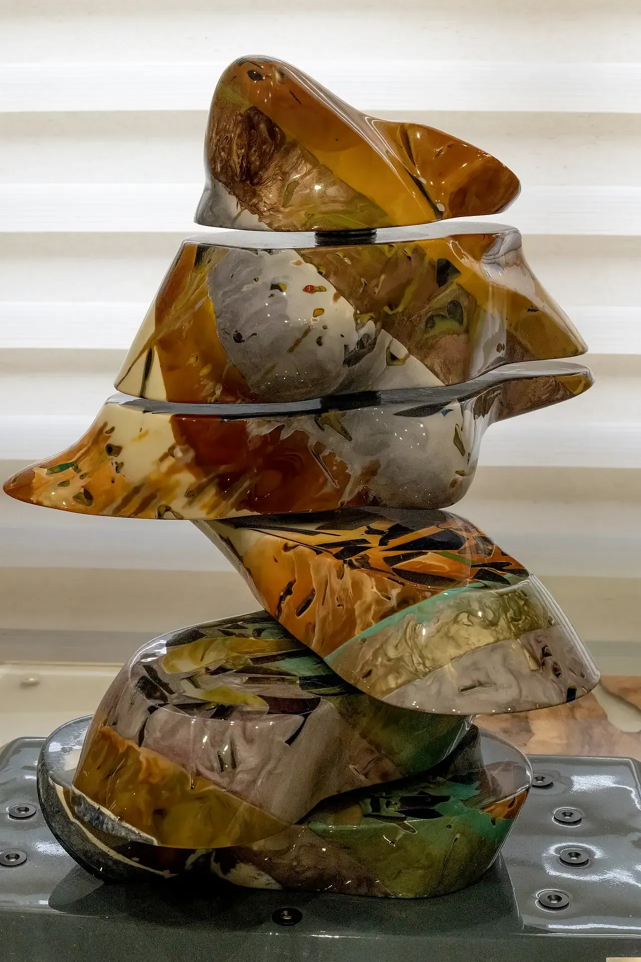 Primo piano della scultura cinetica di torso femminile di Guerino Rusconi, realizzata in resina policroma con sezioni mobili. La foto evidenzia la complessa stratificazione dei segmenti in resina dalle tonalità terrose e iridescenti e la dinamicità della composizione.