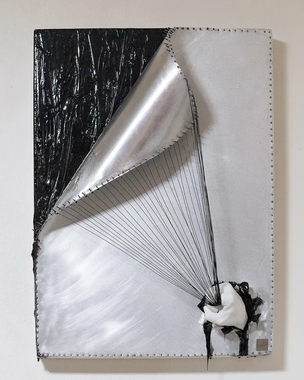 Scultura tridimensionale in resina bianca mista con leghe metalliche con una mano che impugna fili in acciaio.