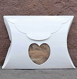 a white pillow box with a heart cut out of it .
