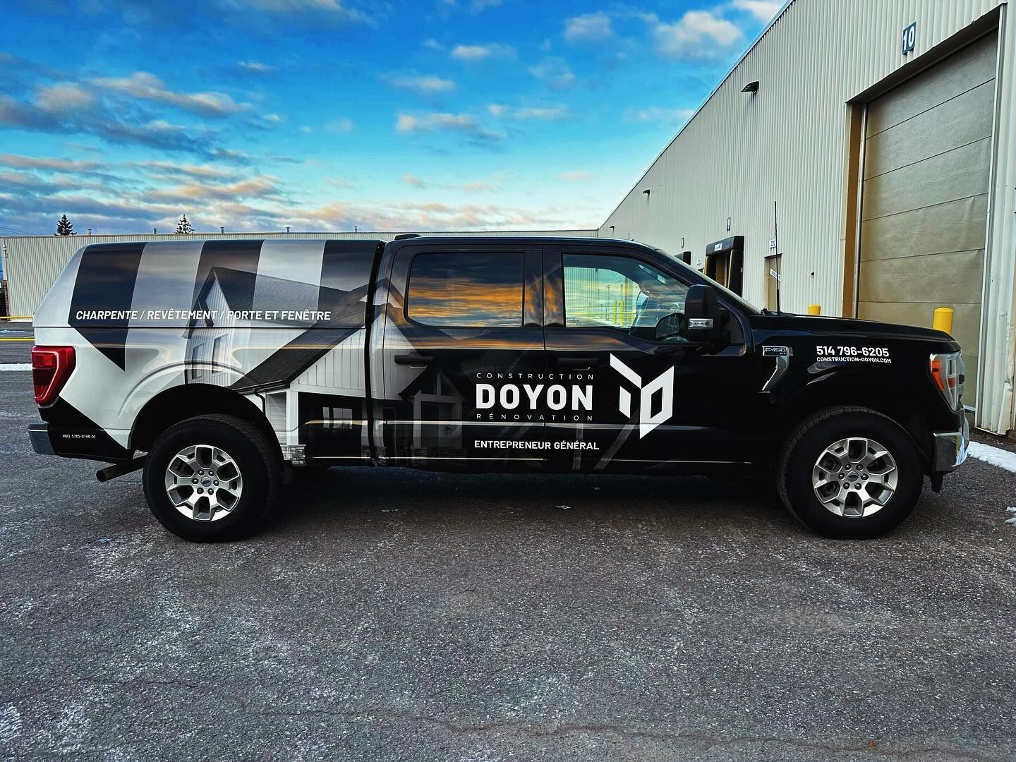 An interior view of a room under construction, showing wooden framing, exposed rafters, and pink insulation in the walls.