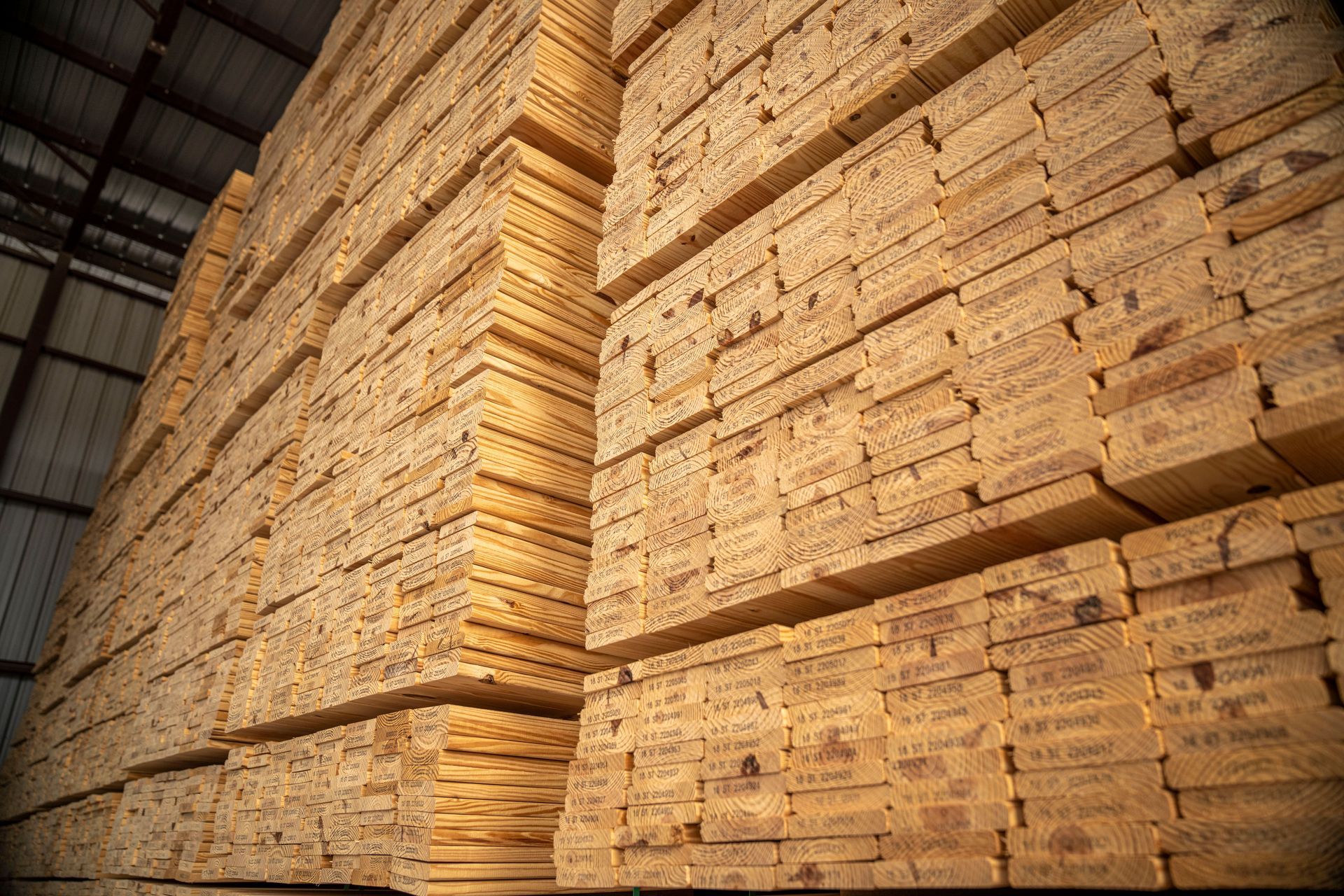 Stacks of lumber piled high inside a warehouse