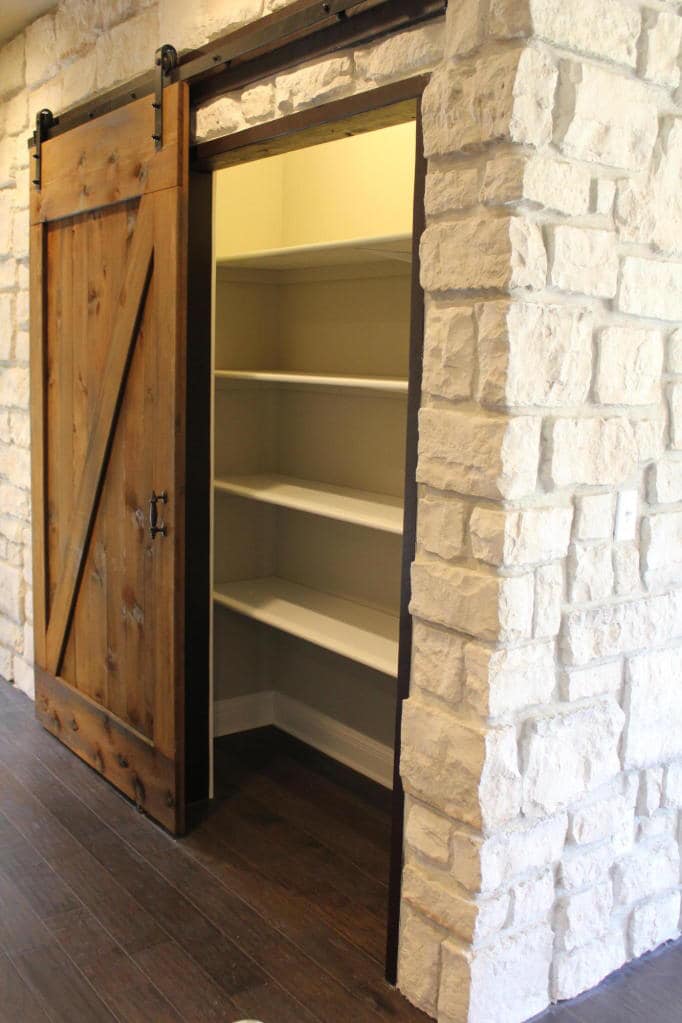 Close-up of closet with sliding barn door by Timberwood Homes