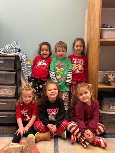 A group of children are sitting on the floor in a room.
