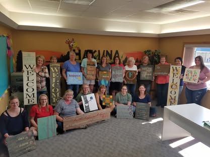 A group of women are standing in a room holding signs.