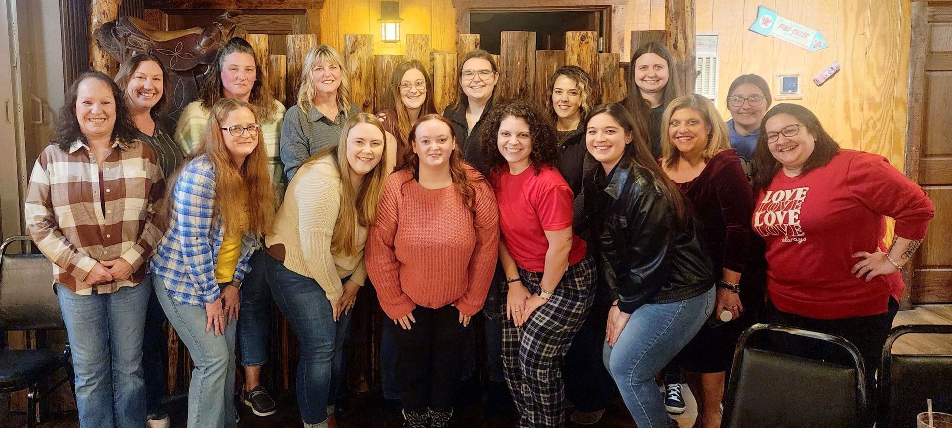 A group of women are posing for a picture together in a room.