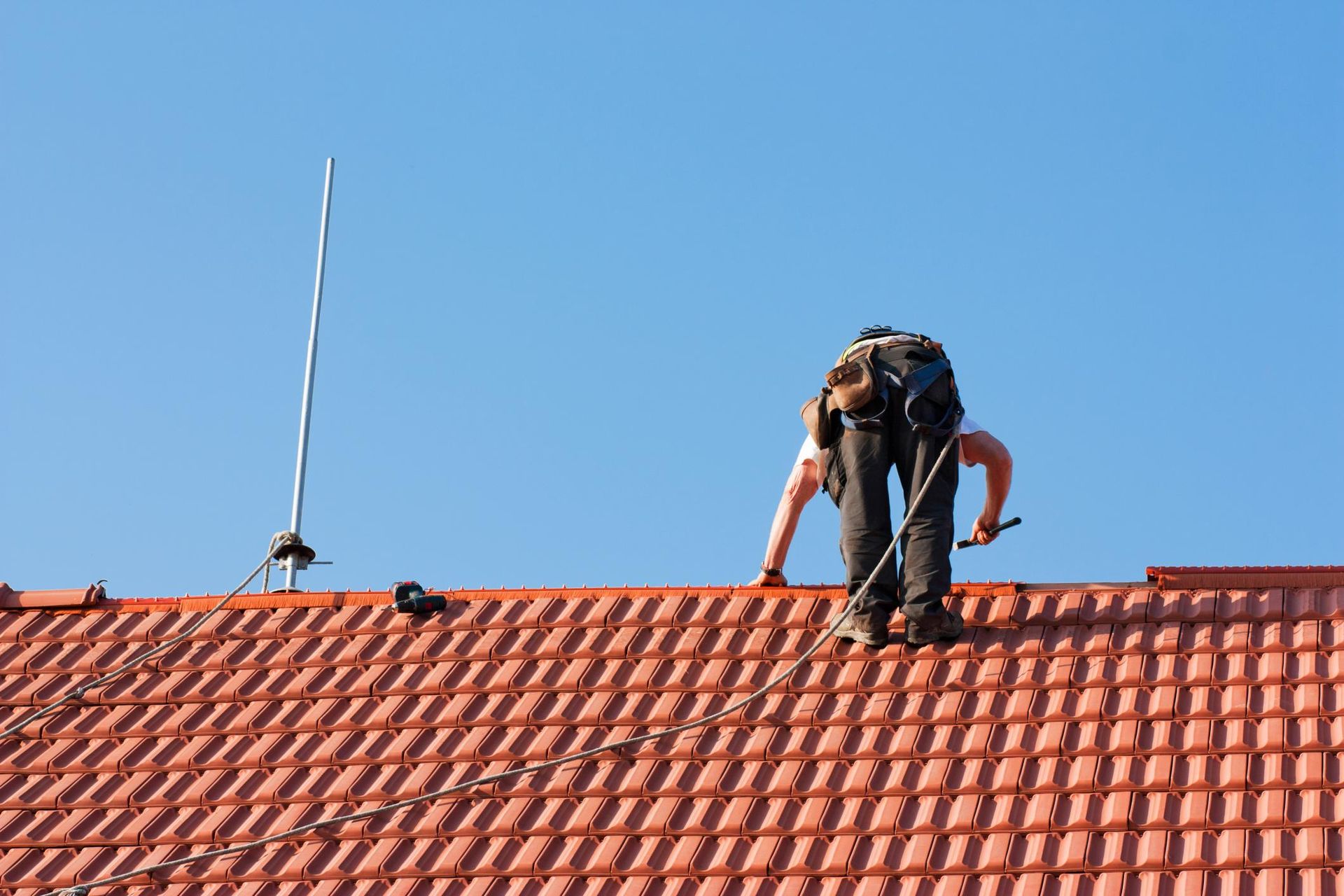 A man is working on the roof of a house