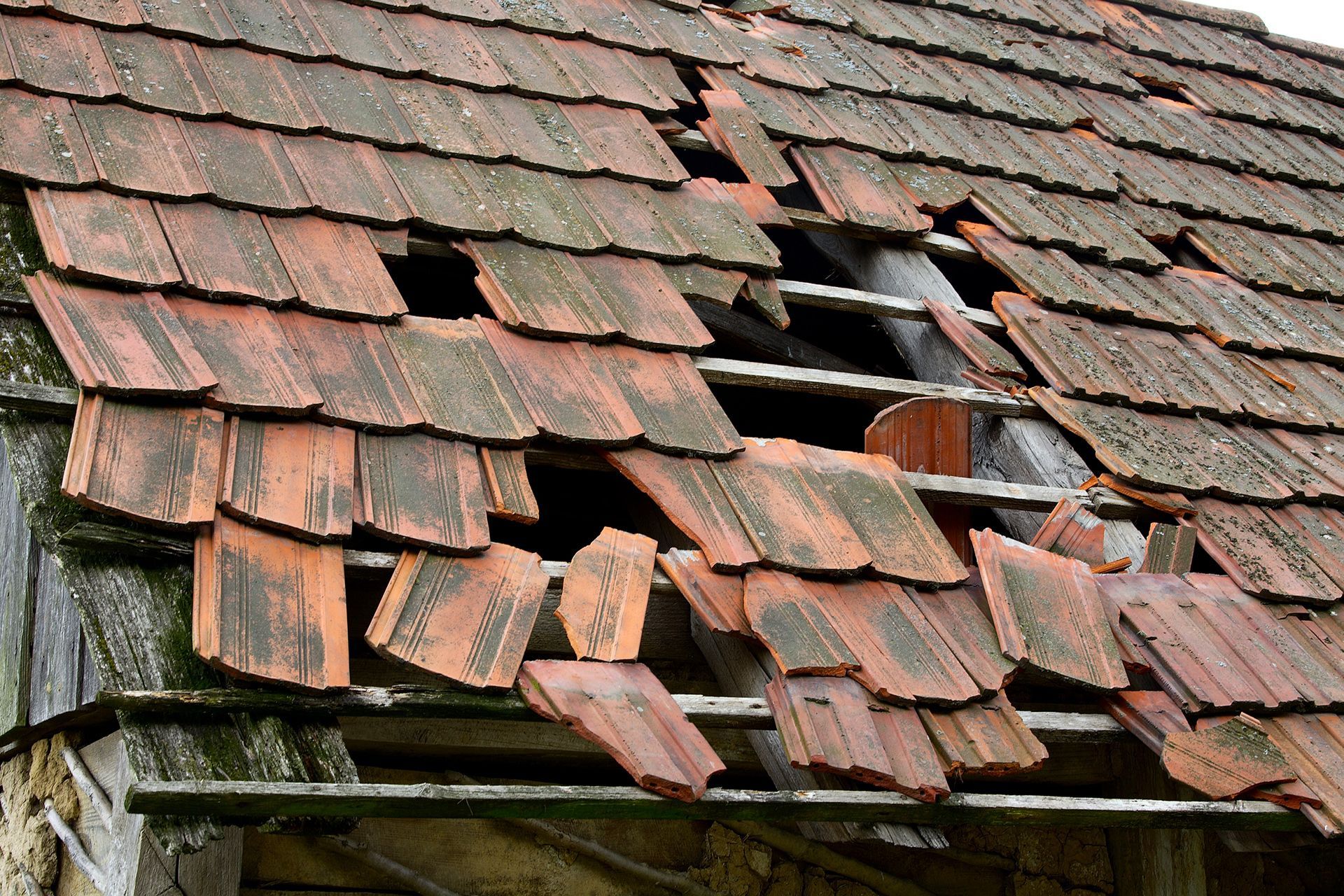 A roof with a lot of broken tiles on it
