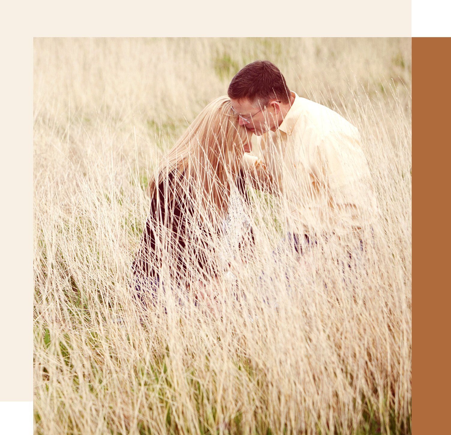 Husband and wife in grassy field kneeling together to pray