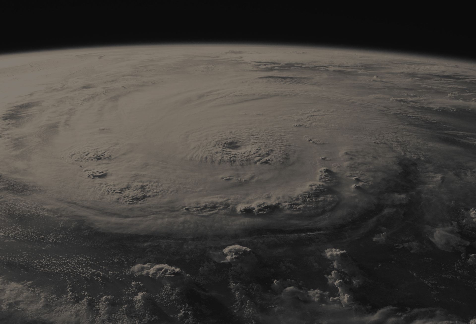A black and white photo of a hurricane on earth taken from space.