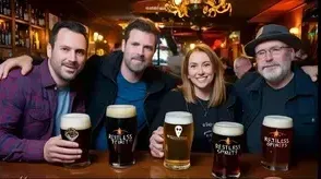 A group of people are sitting at a table holding glasses of beer.
