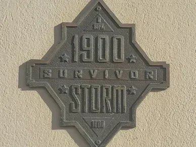 A sign on a wall that says 1900 survivor storm