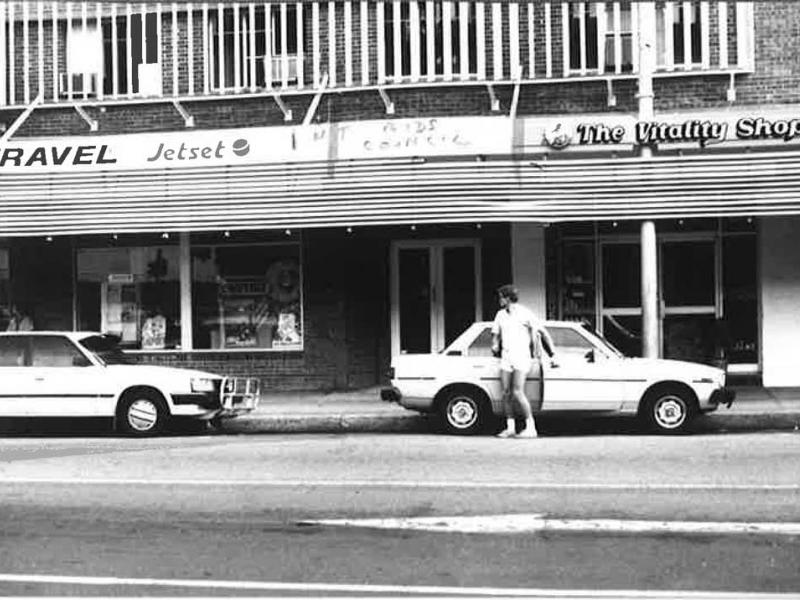 A black and white photo of a store called the quality shop