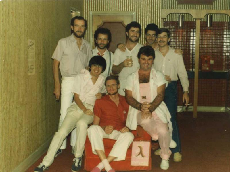 A group of men are posing for a picture in a hallway.