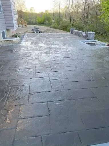 A patio is being built in the backyard of a house.