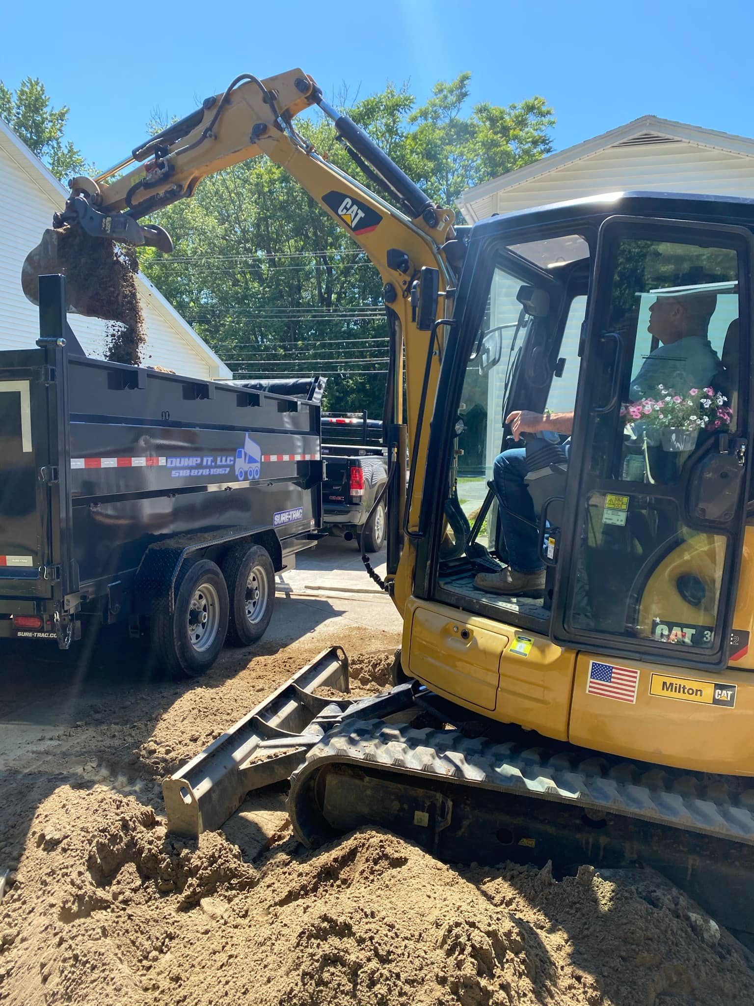 A bulldozer is digging a hole in the ground next to a dumpster.