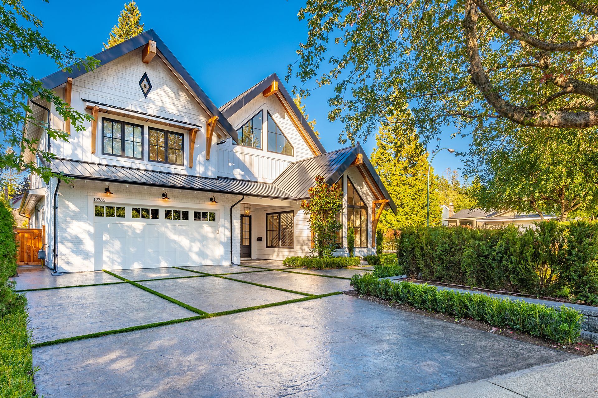 A large white house with a large driveway in front of it.