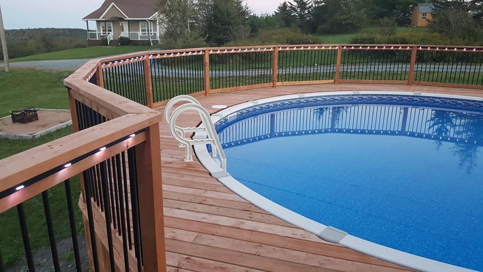 A large swimming pool is surrounded by a wooden deck.