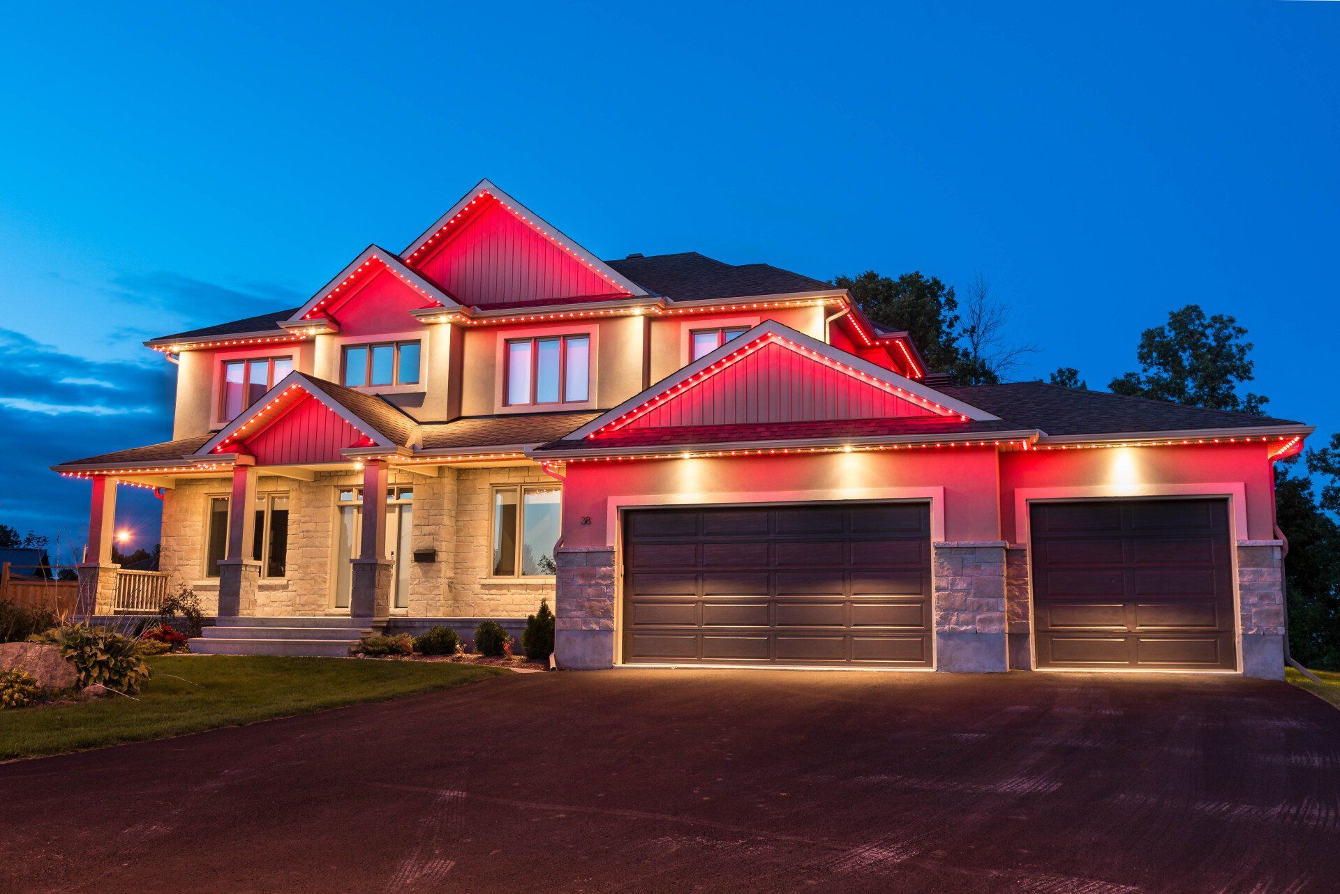 A large house with a red roof is lit up at night