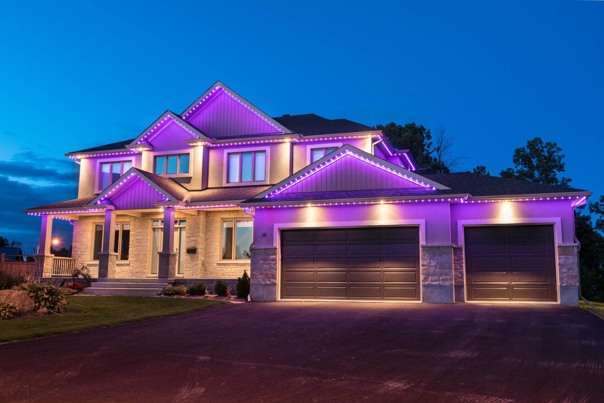 A large house with purple lights on it at night