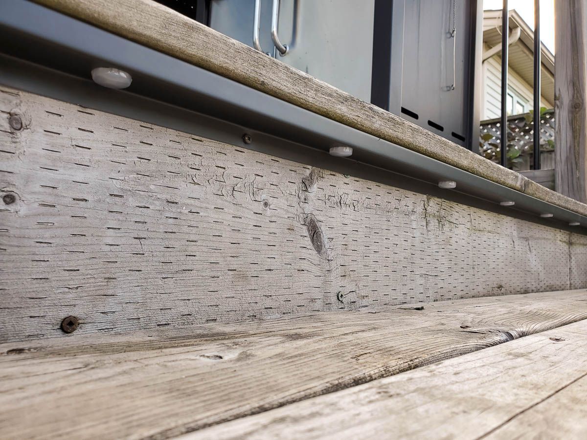 A close up of a wooden deck with a metal railing
