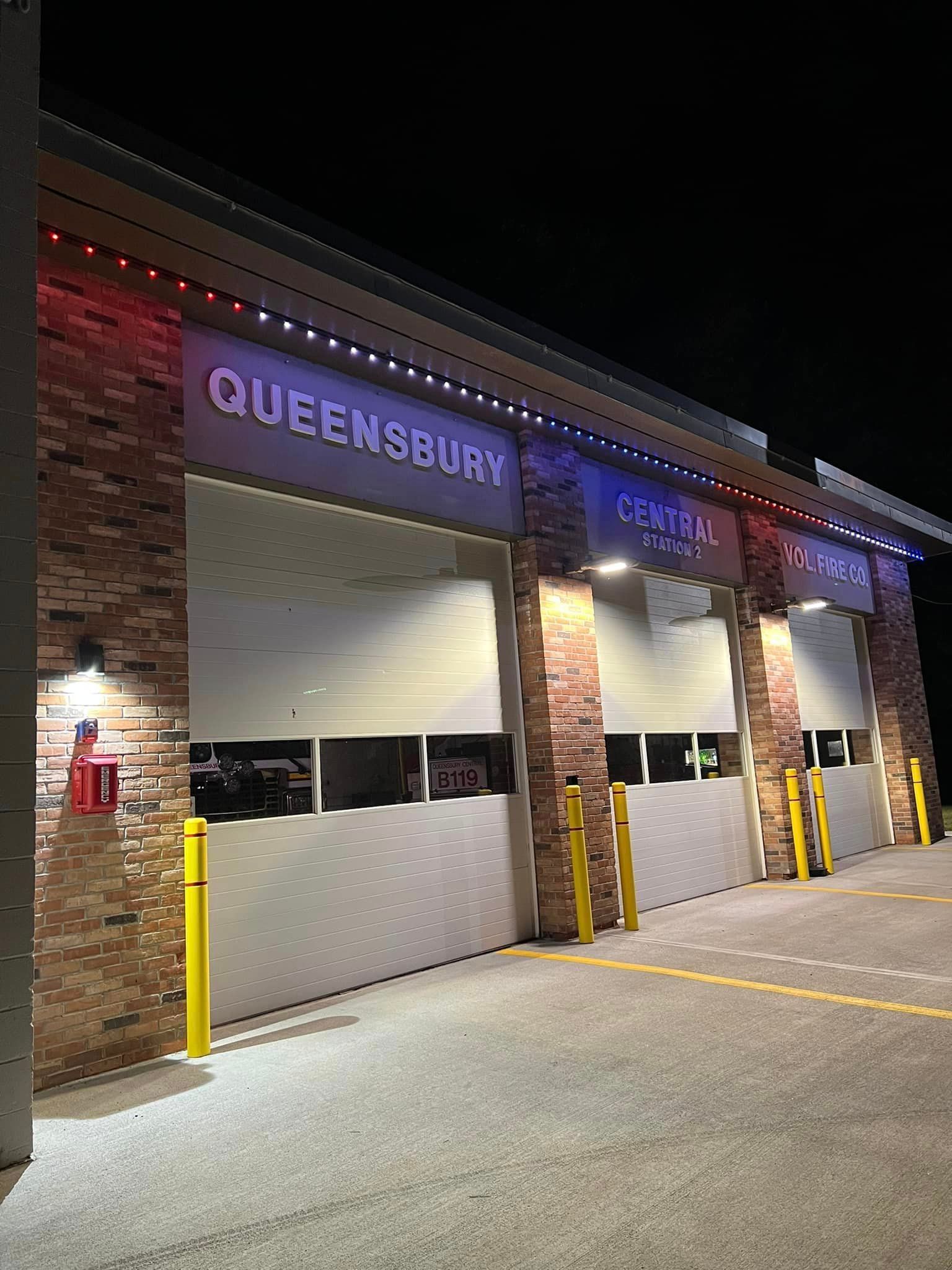 A building with a lot of garage doors is lit up at night.