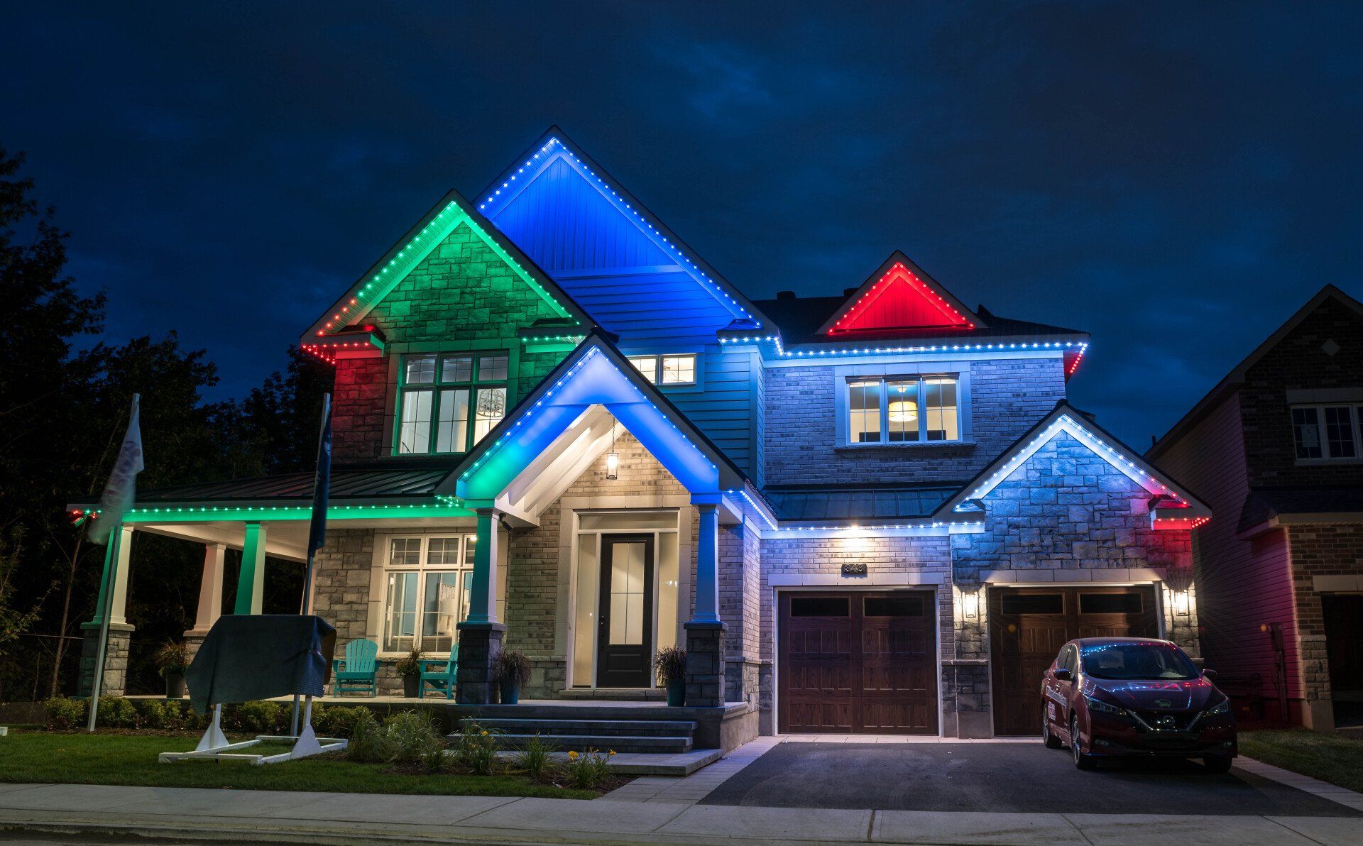 A house with christmas lights on it is lit up at night.