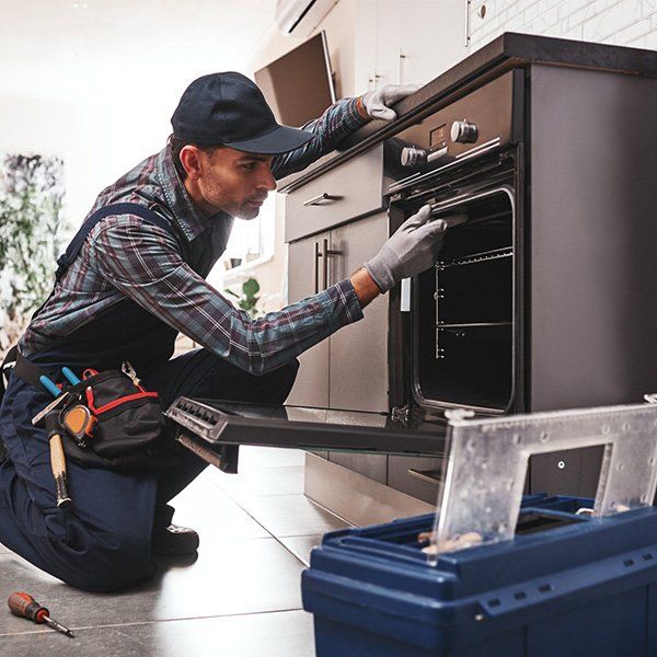 Repairman Examining Oven — Seal Tite in Tweed Heads South, NSW