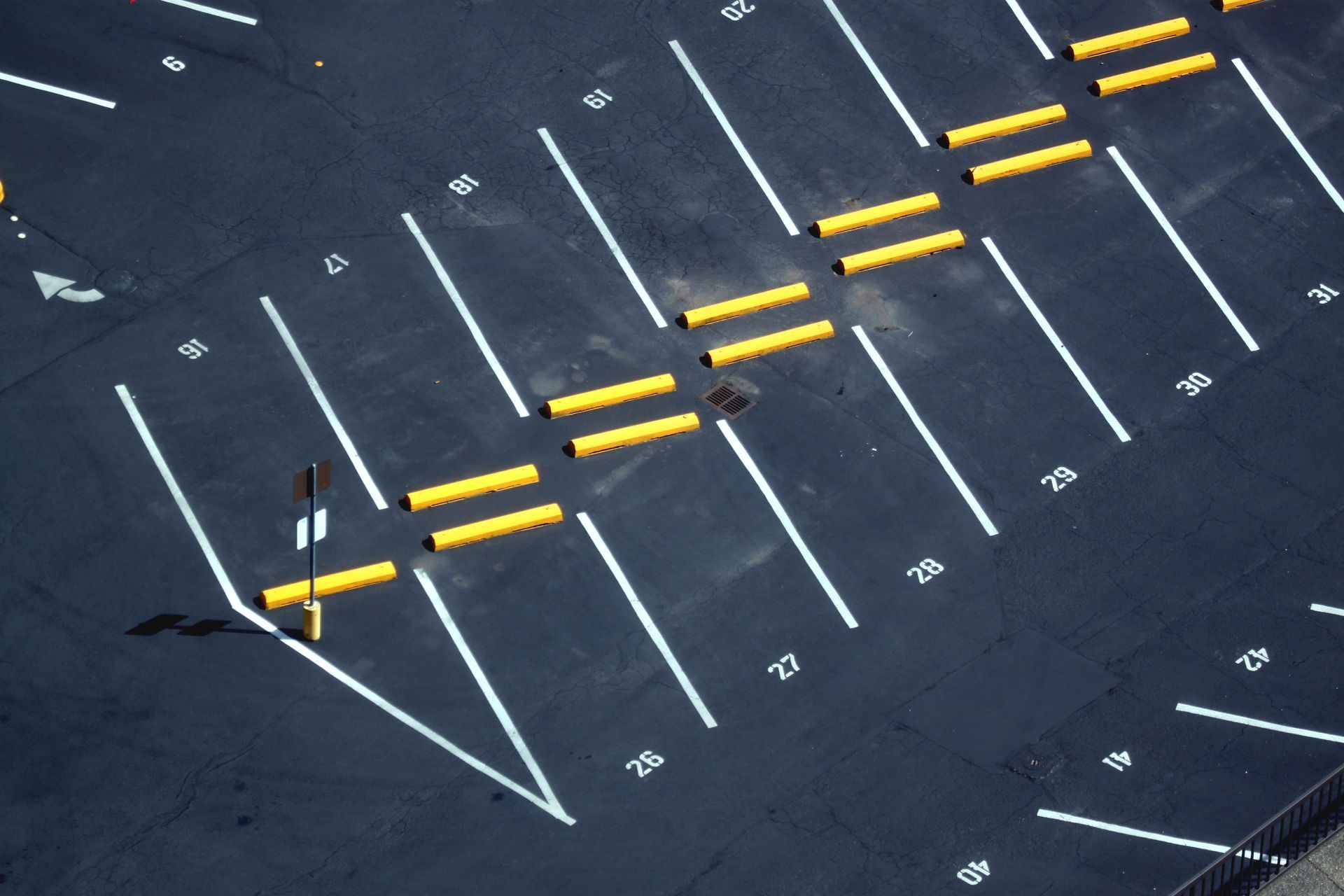 An aerial view of a parking lot with yellow lines and white lines