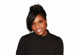 Woman with dark hair, wearing a black top, smiles. White background.
