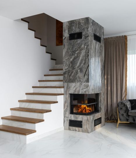 A living room with a staircase and a fireplace