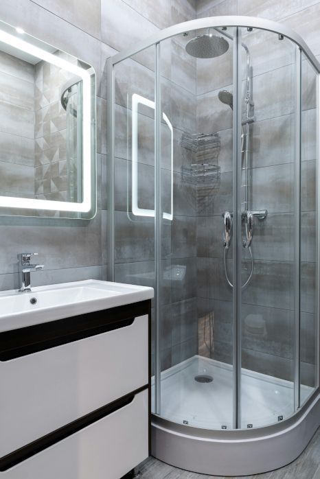 A bathroom with a toilet , sink , bathtub and shower. Professionally tiled by Orchid Tiling in Newport, Wales.